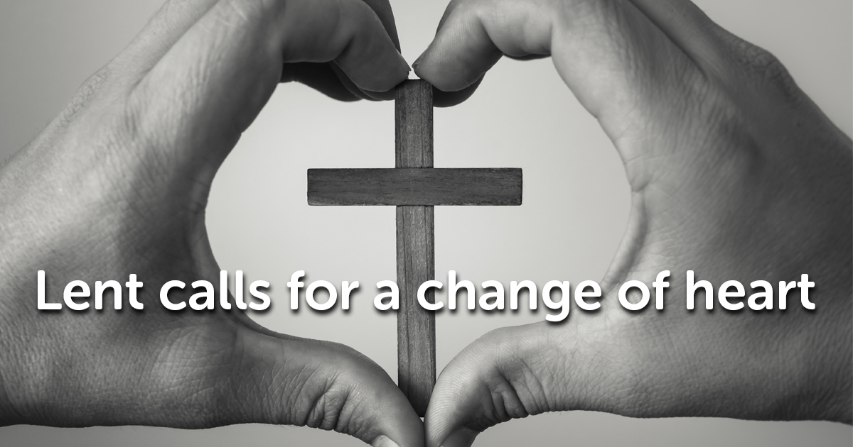 Black and white image of two hands forming a heart shape, framing a wooden cross in the center. The text "Lent calls for a change of heart" is overlaid on the image.